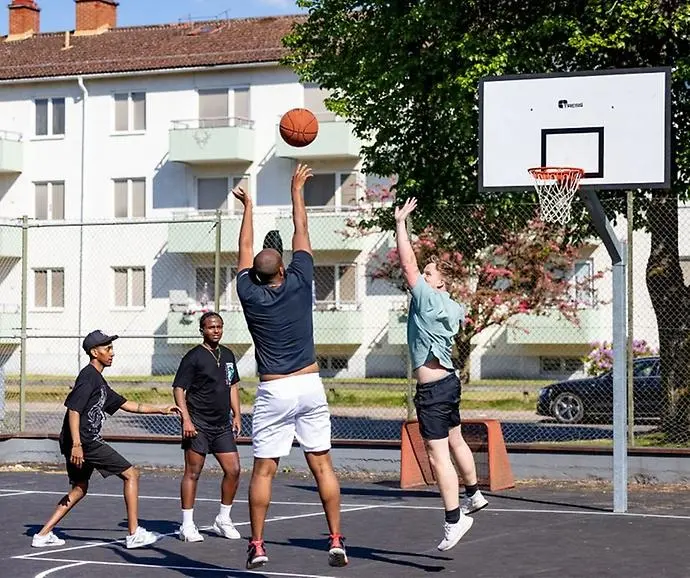 Bild på fyra ungdomar som spelar basket. 