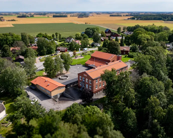 En flygbild av en skolbyggnad omgiven av träd.