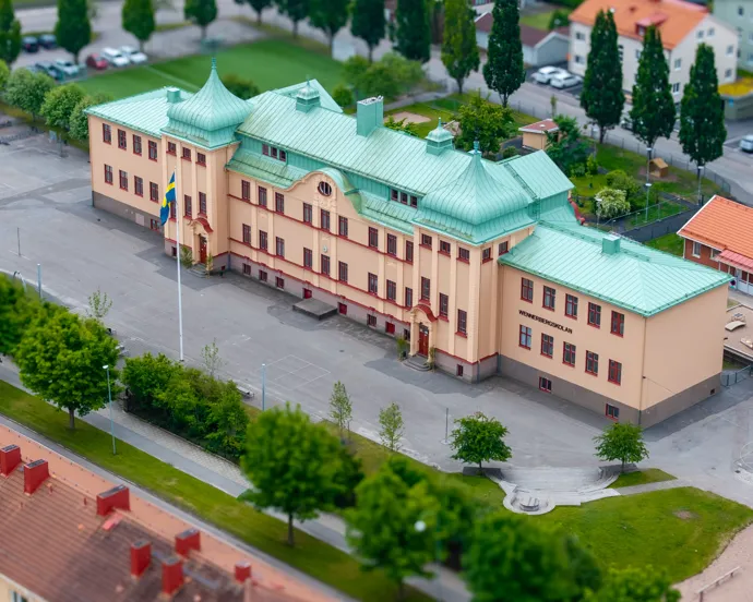 En flygbild av en skolbyggnad med ett grönt tak.