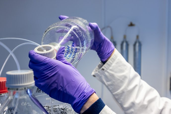 Laborant som mäter vätska 